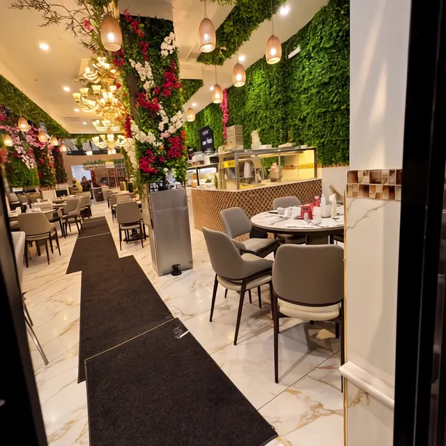 View from the front door down the aisle runner, past tables and foliage walls