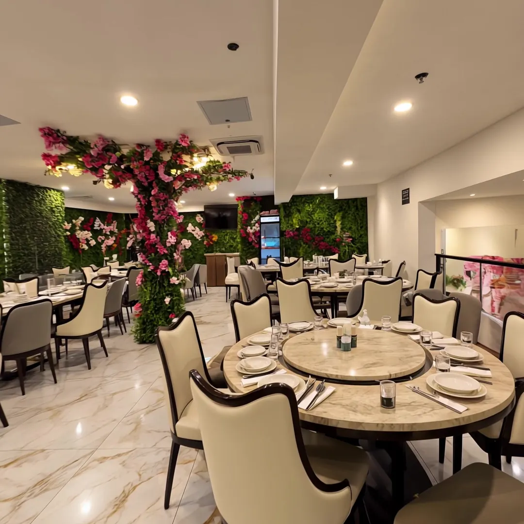 Upstairs dining room with a large round table and a blossom tree