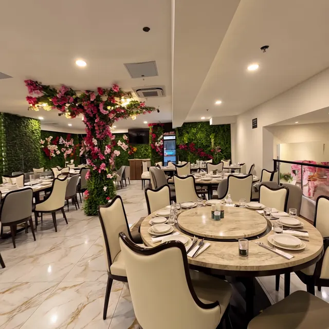 Upstairs dining room with round tables and a blossom tree